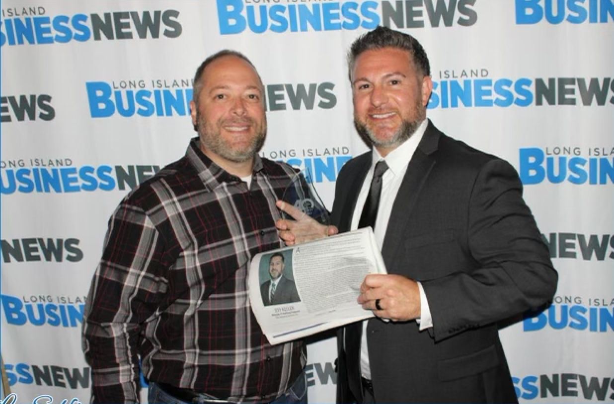 Elite Technical Senior Recruiter John Keller, left, poses with Jeff Keller in front of Long Island Business News backdrop at 40 Under Forty awards  dinner.