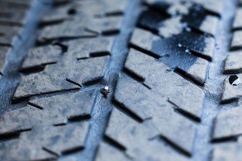 A close up of a tire with a screw in it.