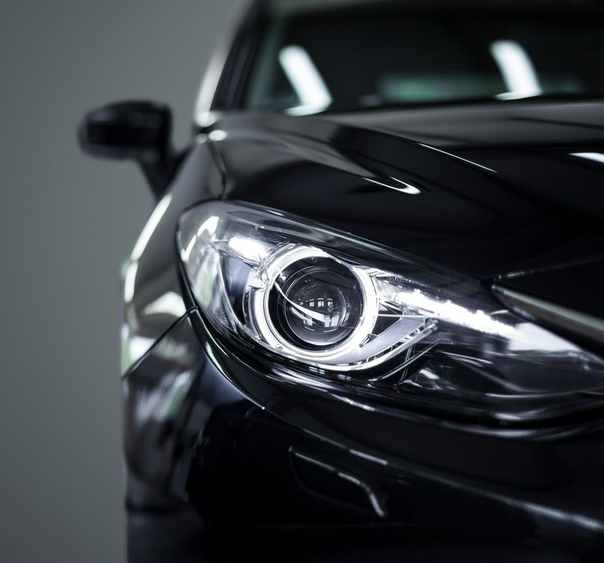 A close up of the headlight of a black car