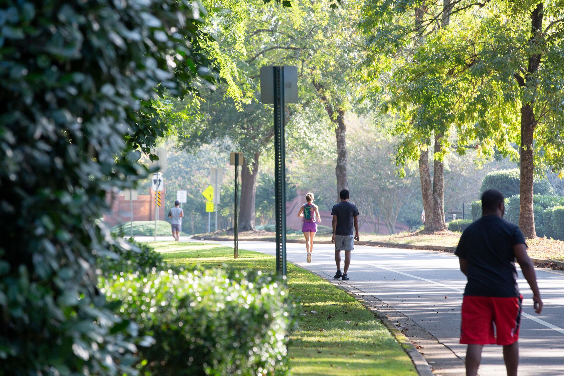 A man and a woman are walking down a sidewalk.