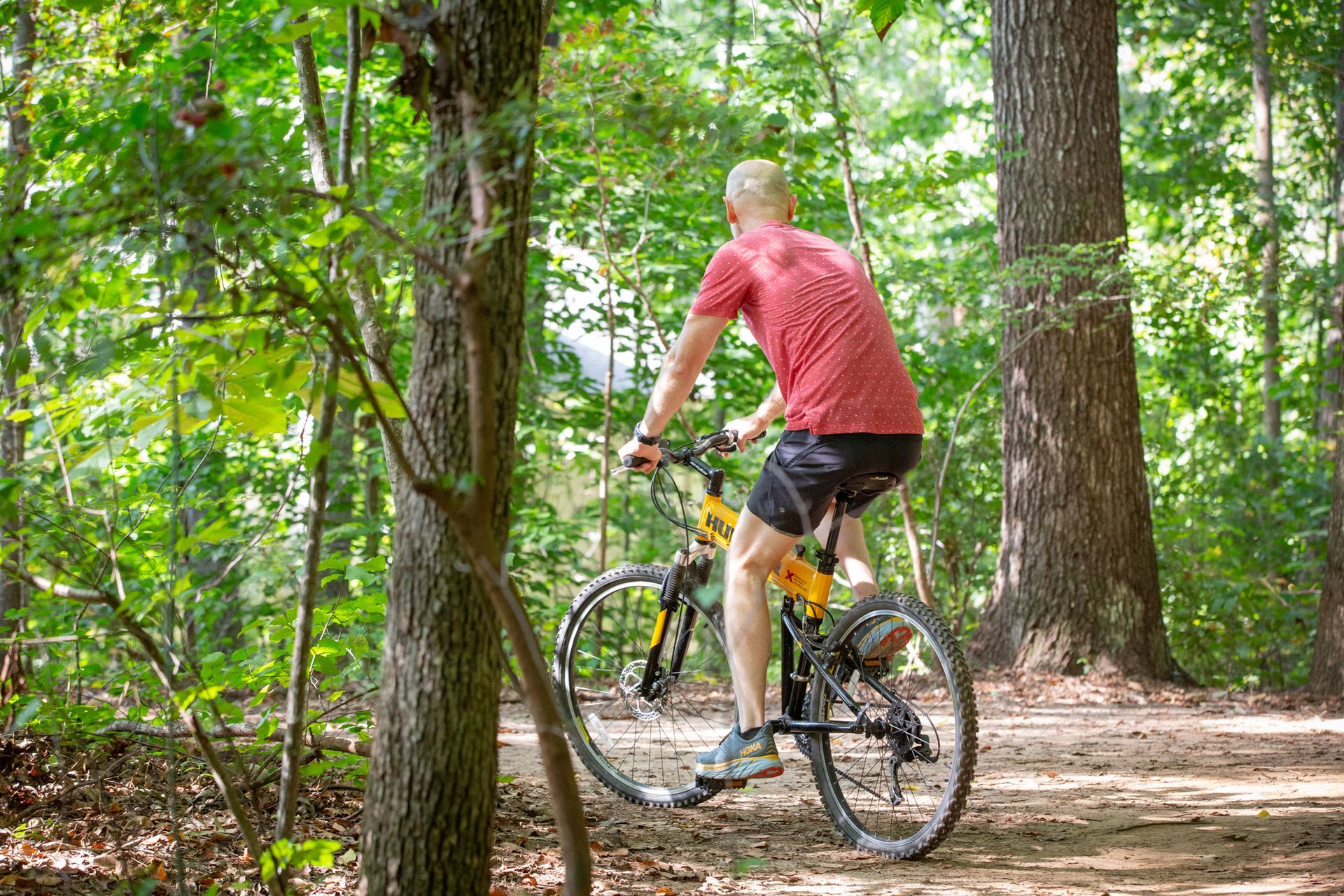 A man is riding a bike on a trail in the woods.