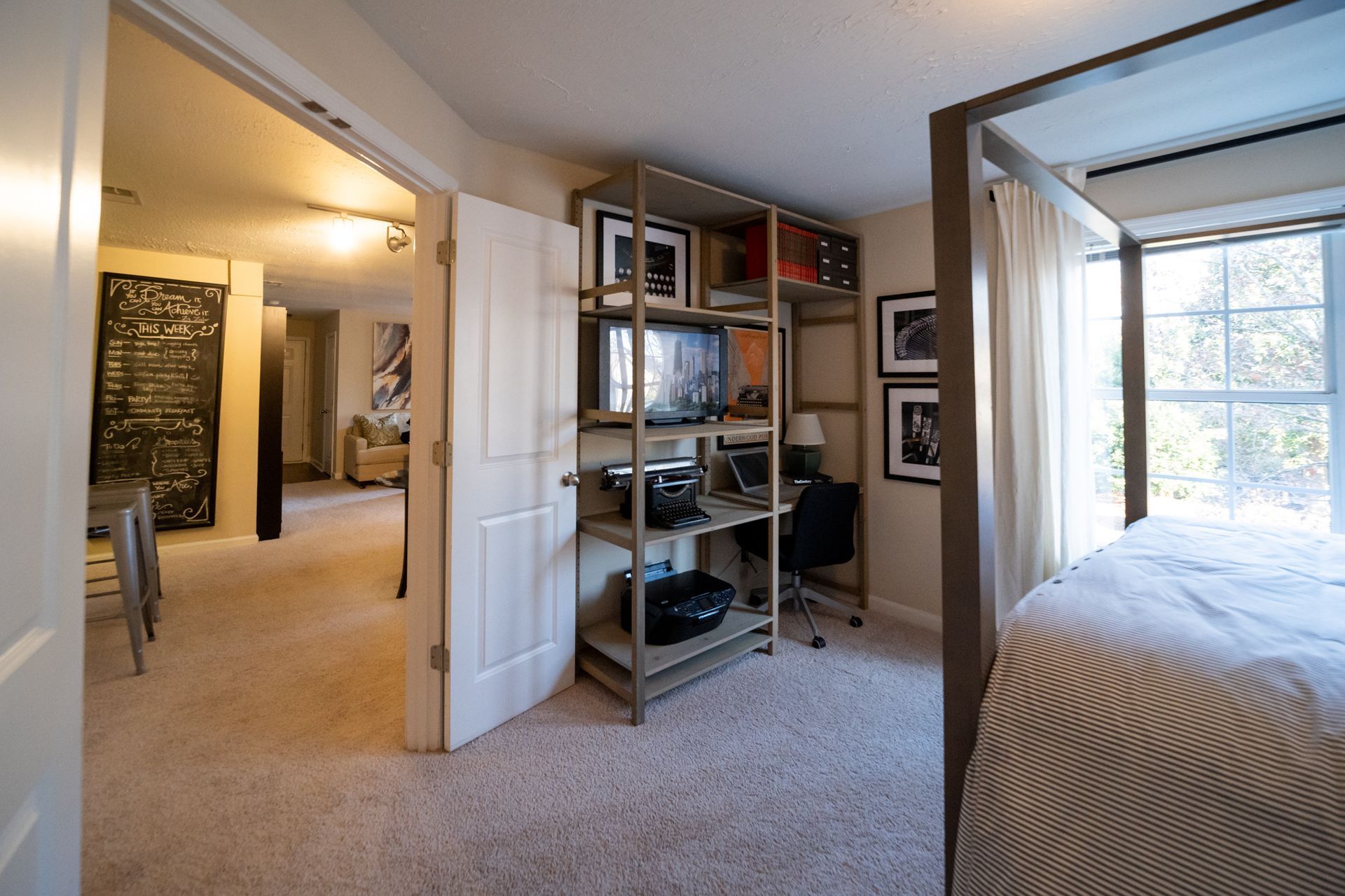 A bedroom with a four poster bed and a desk