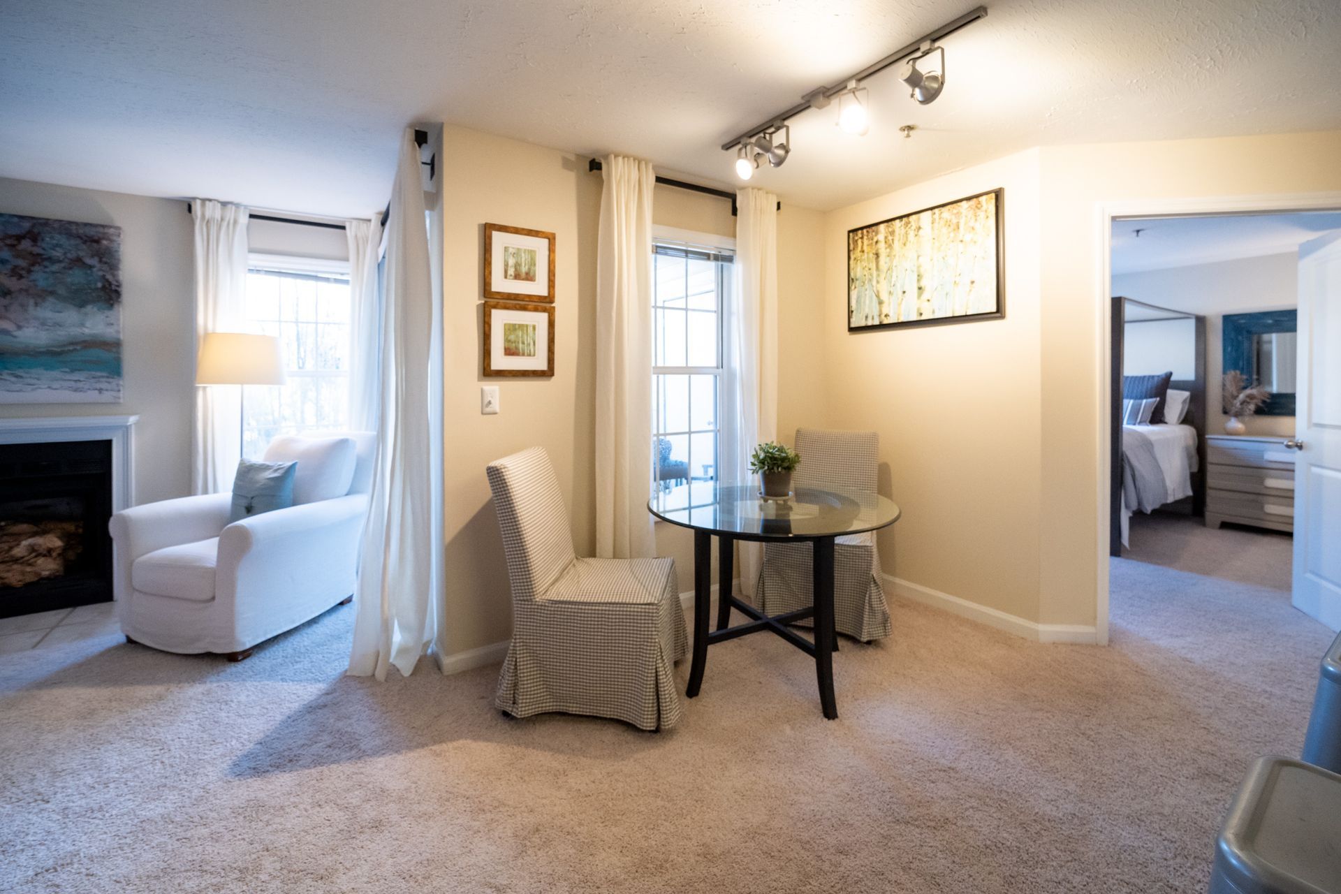 A living room with a table and chairs and a fireplace.