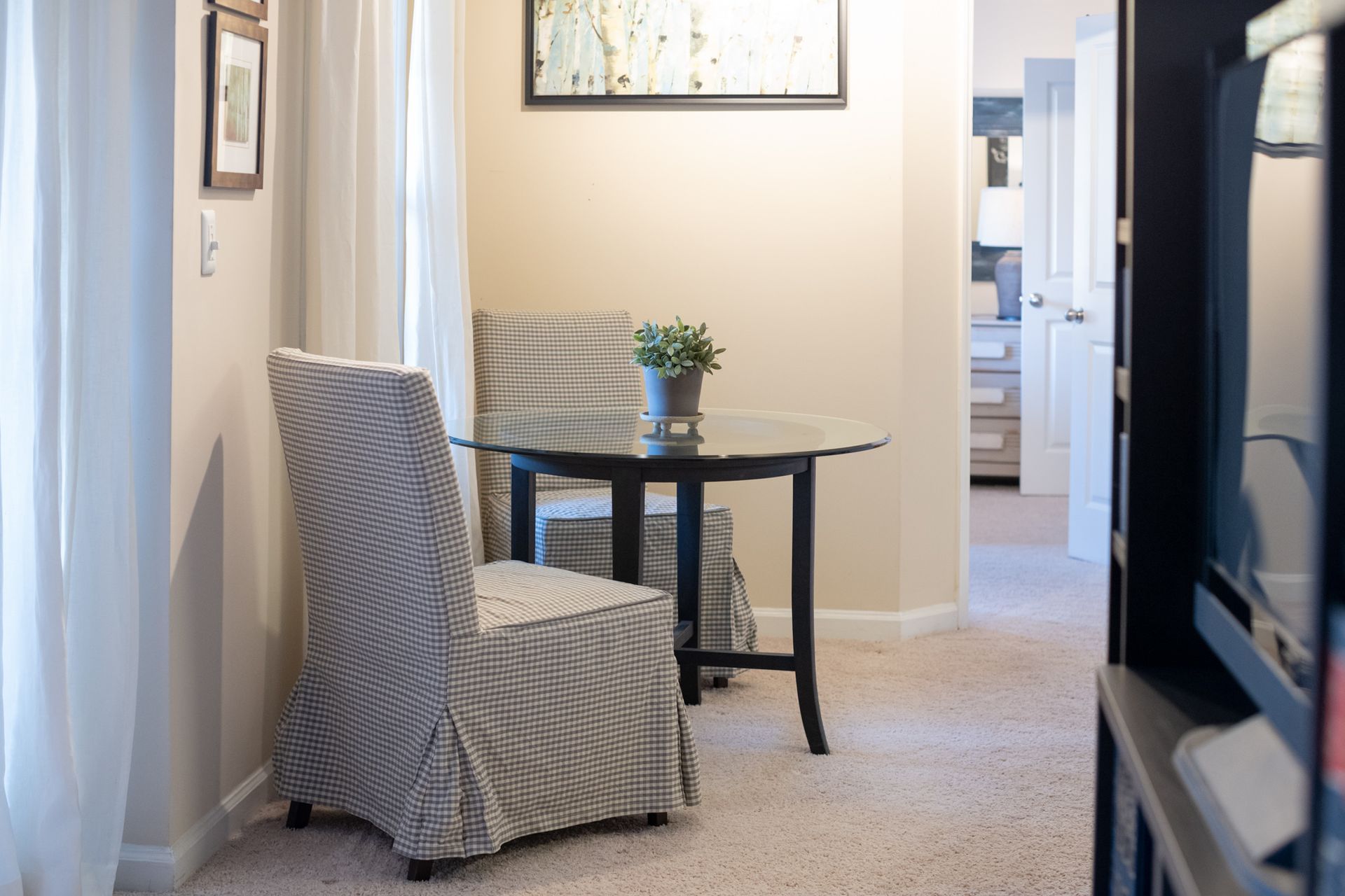 A living room with a table and chairs and a television.