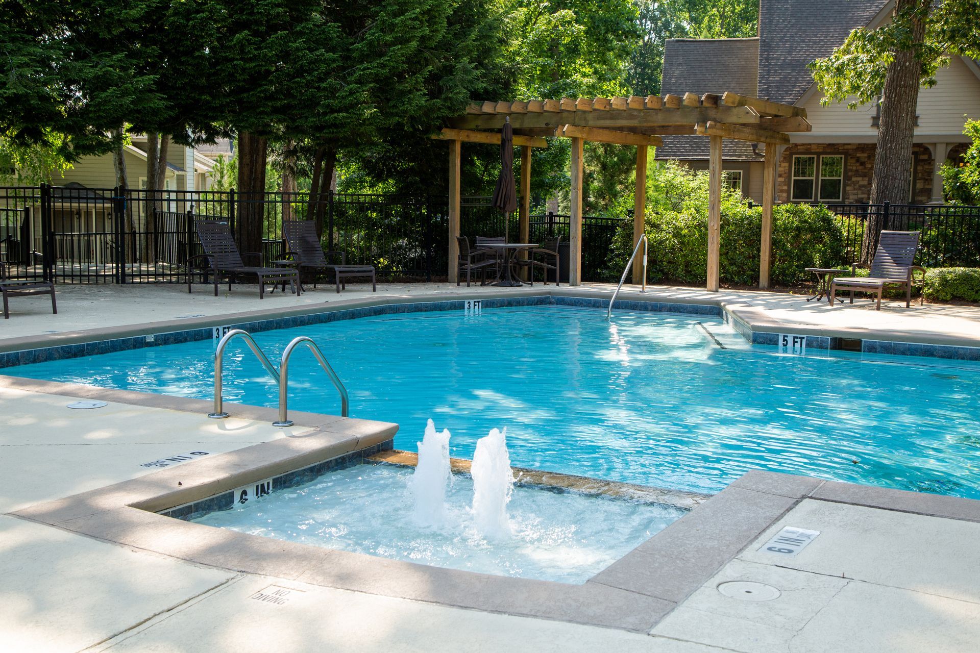 A large swimming pool with a fountain in the middle of it.