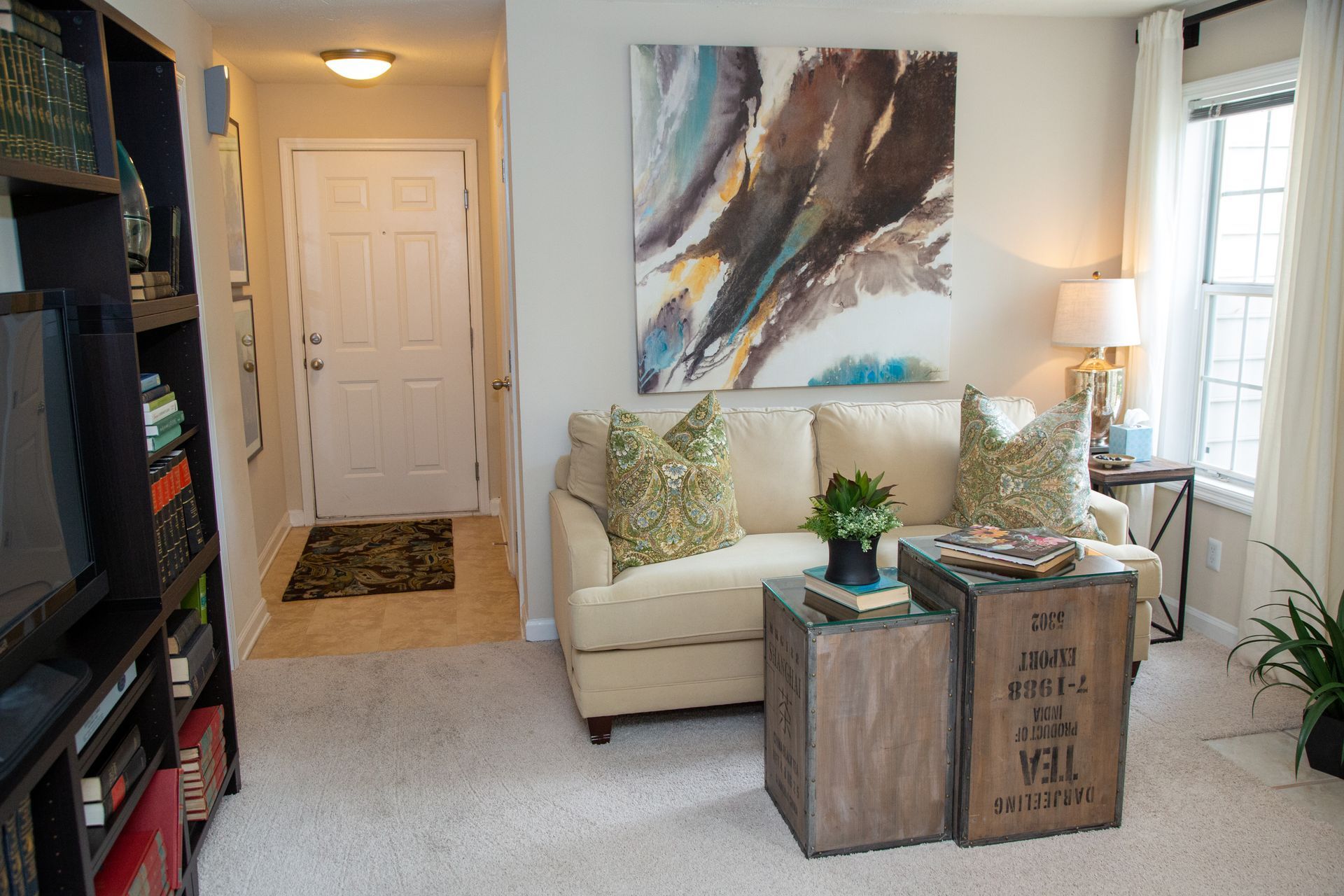 A living room with a couch and a painting on the wall.