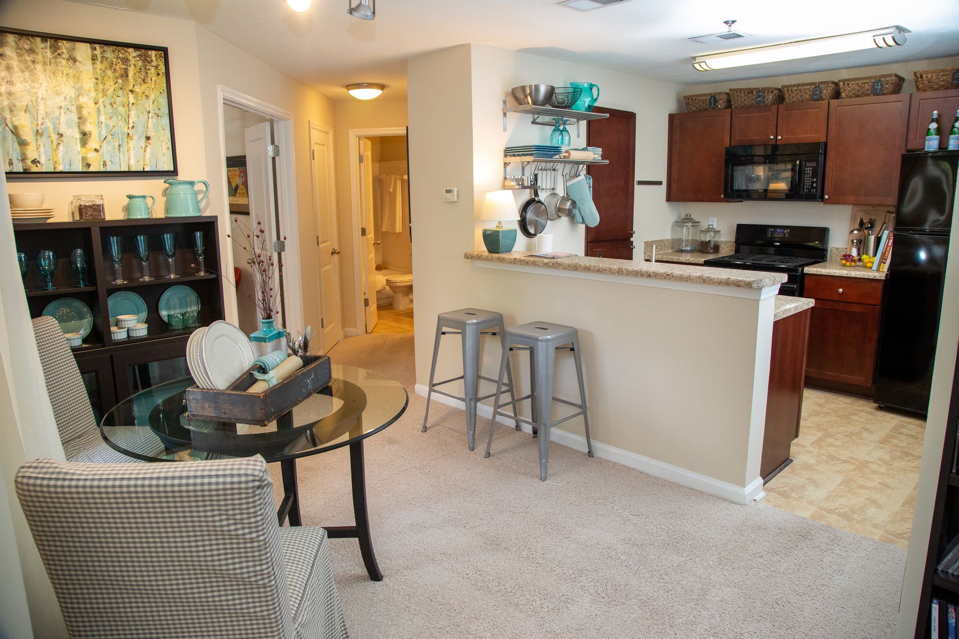 A living room with a table and chairs and a kitchen