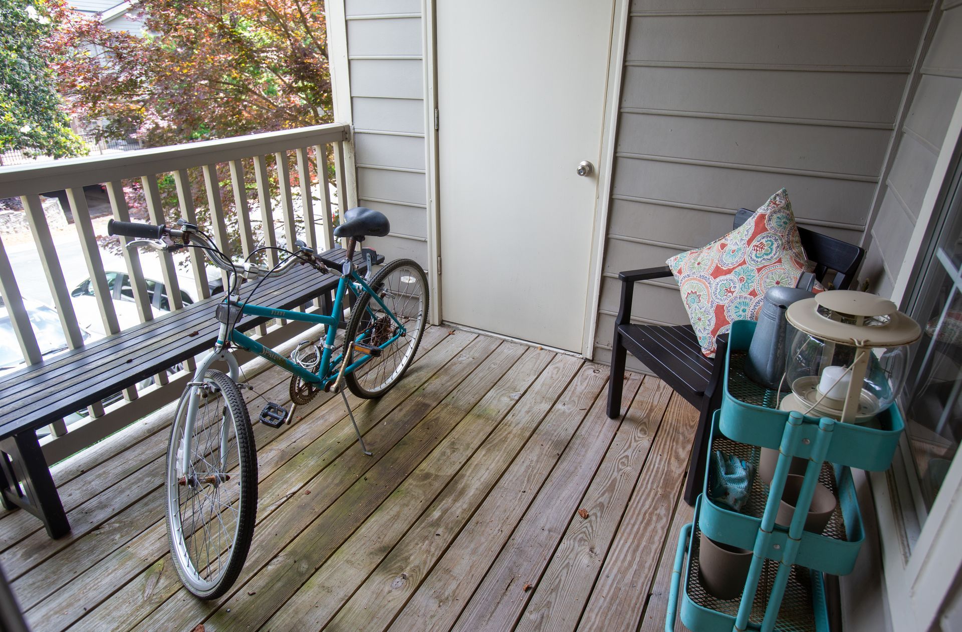 A bicycle is parked on a wooden deck next to a bench.