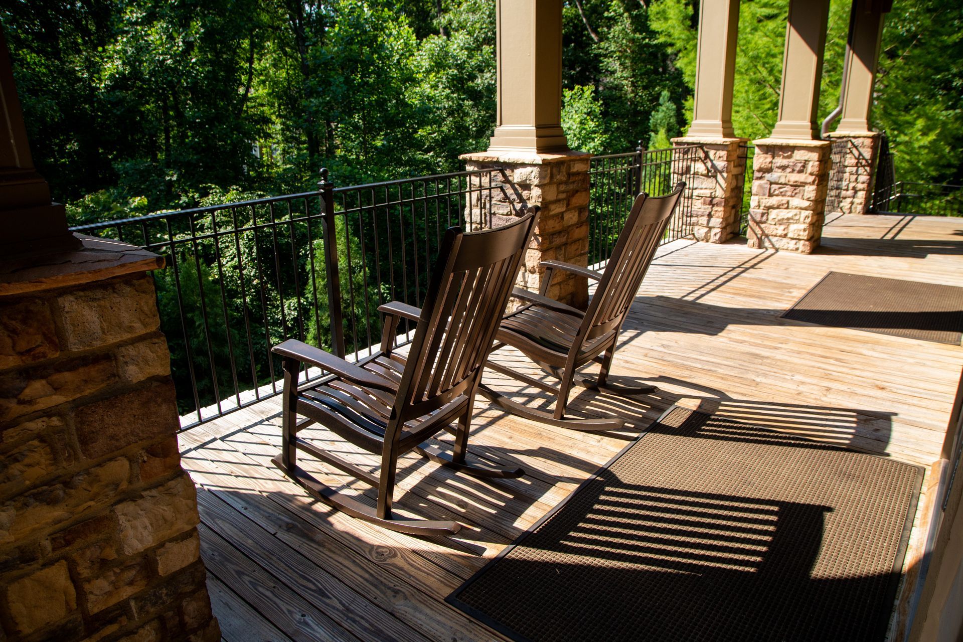 Two rocking chairs are sitting on a wooden deck.