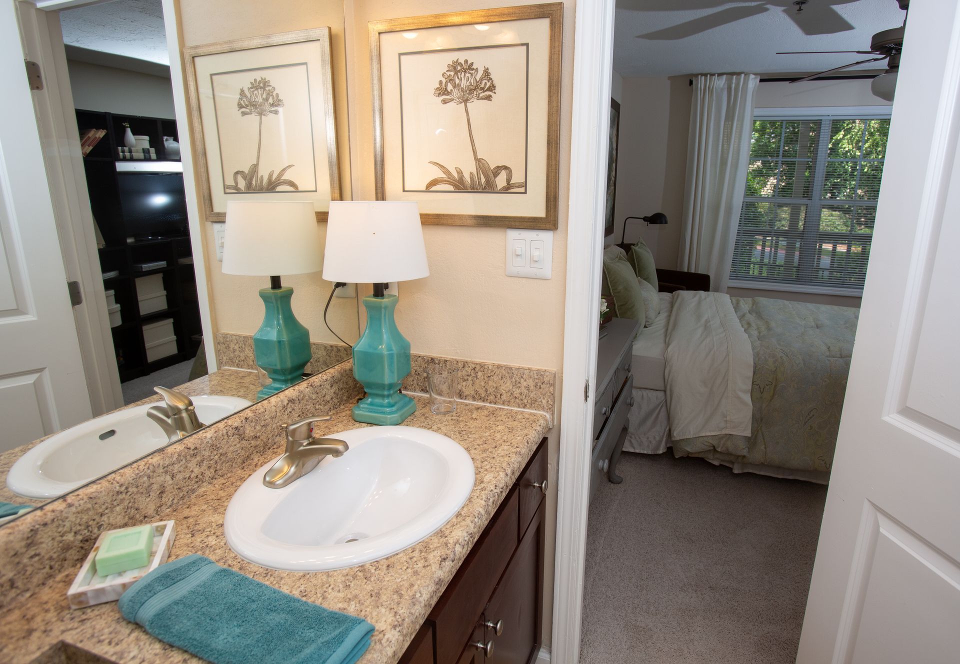 A bathroom with a sink , mirror and two lamps.