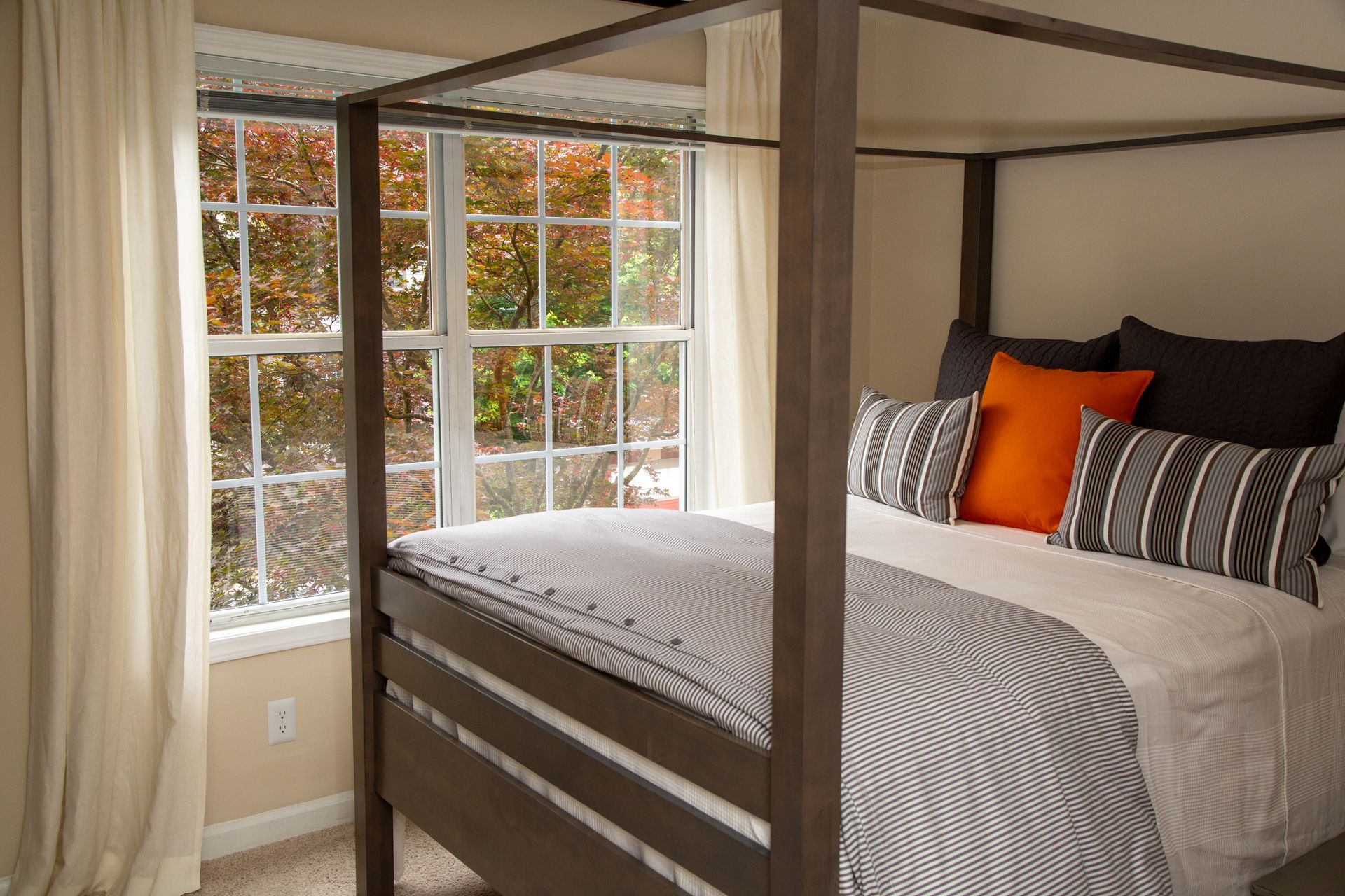 A bedroom with a four poster bed and a window.