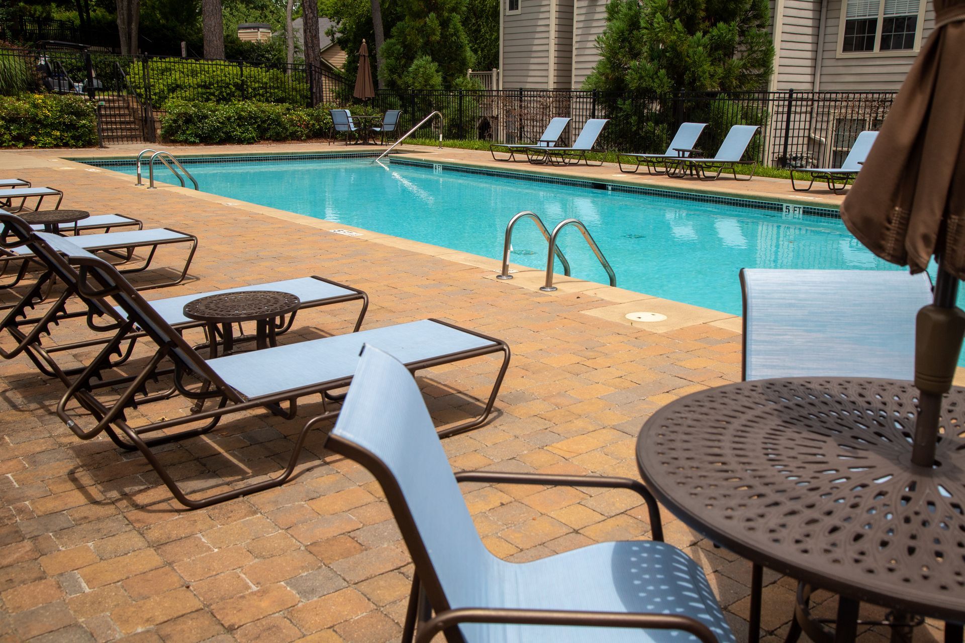 A swimming pool with chairs and tables around it