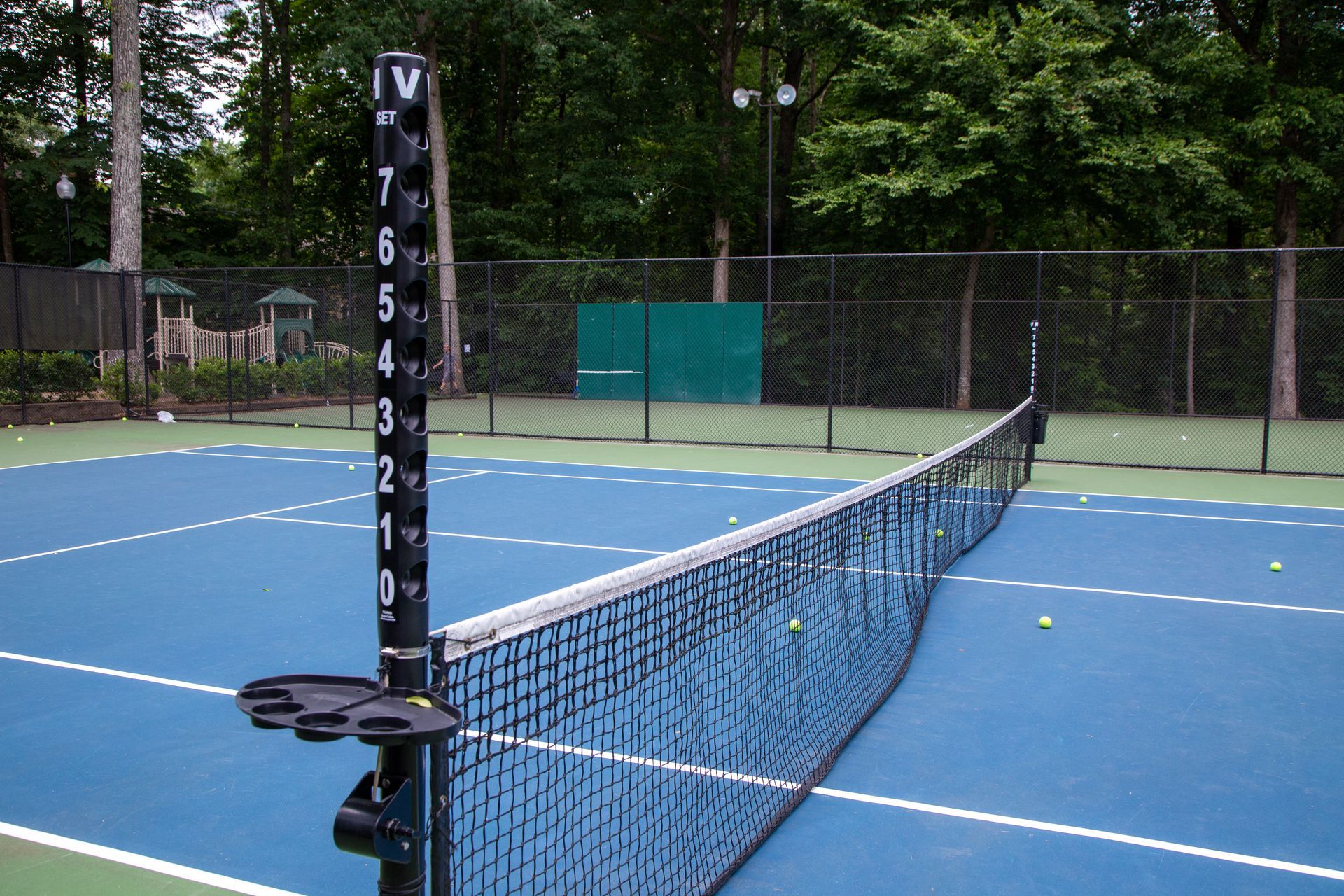 A tennis court with a net that has the letter v on it