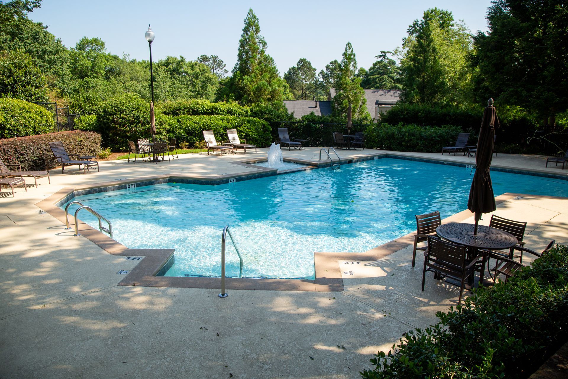 A large swimming pool surrounded by chairs and umbrellas