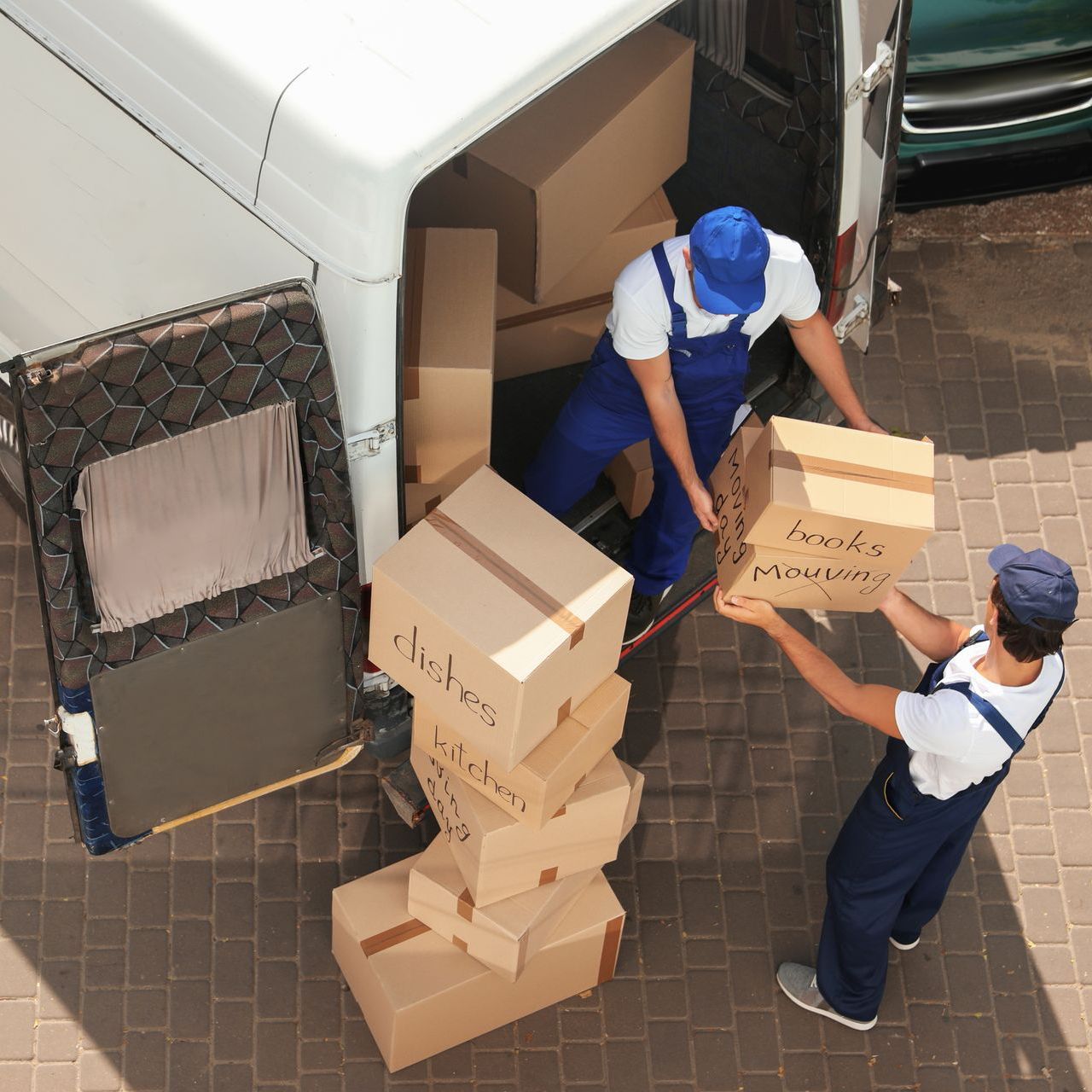 two men are loading boxes into a van .