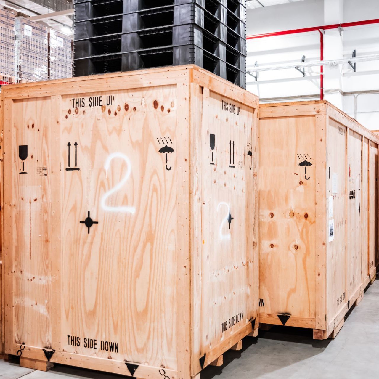 a row of wooden crates are lined up in a warehouse .
