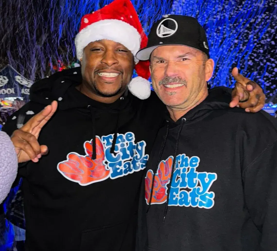 Two smiling men in matching black 