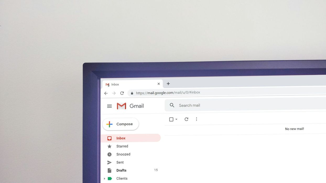 Close-up of a computer monitor displaying a Gmail inbox on a white background.