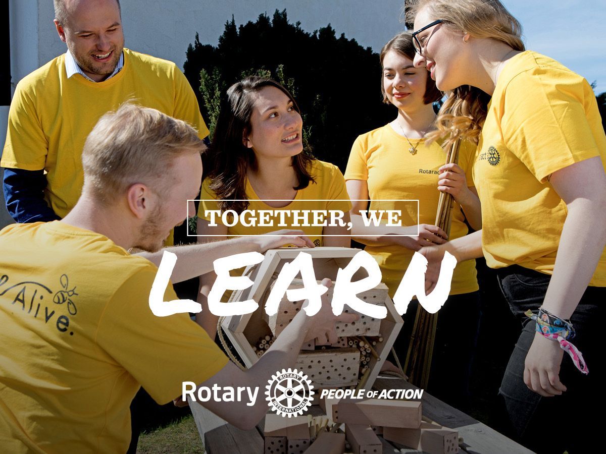 People in yellow shirts building, text 