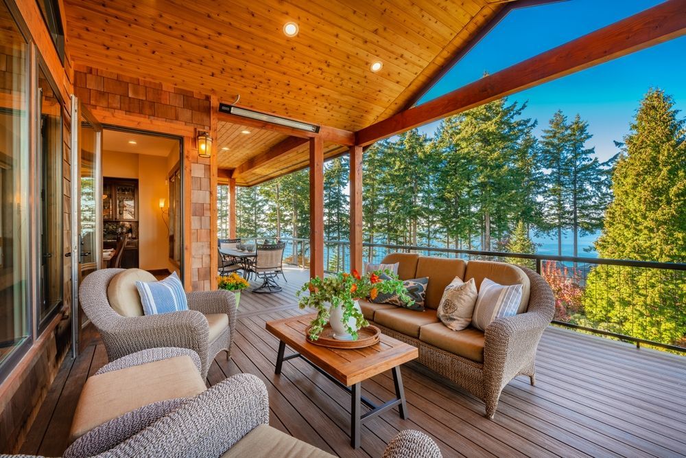 A large deck with a couch , chairs , and a table.