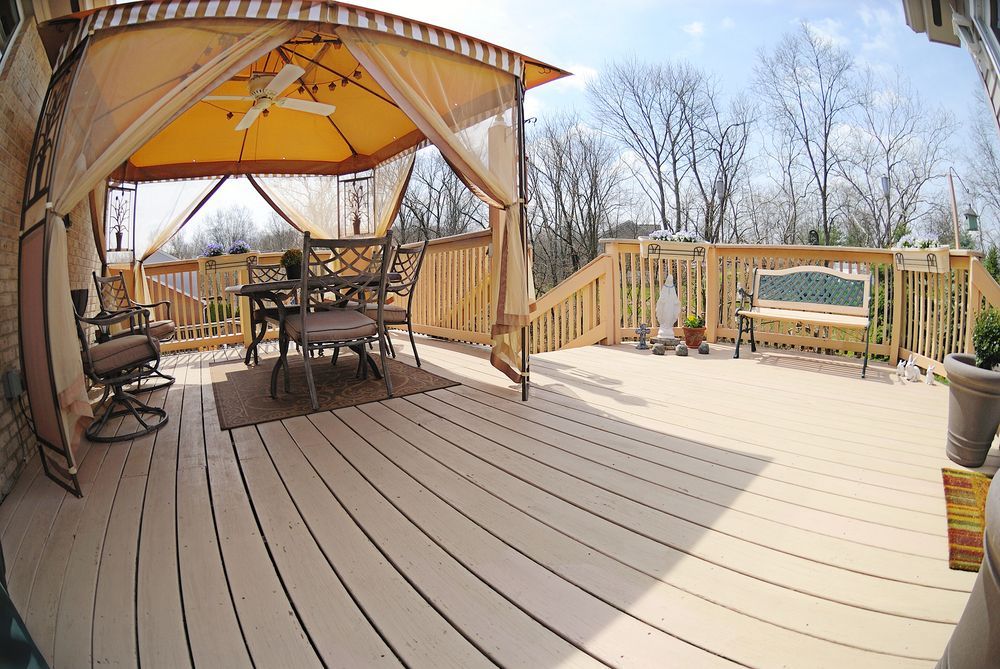 A deck with a gazebo and a table and chairs