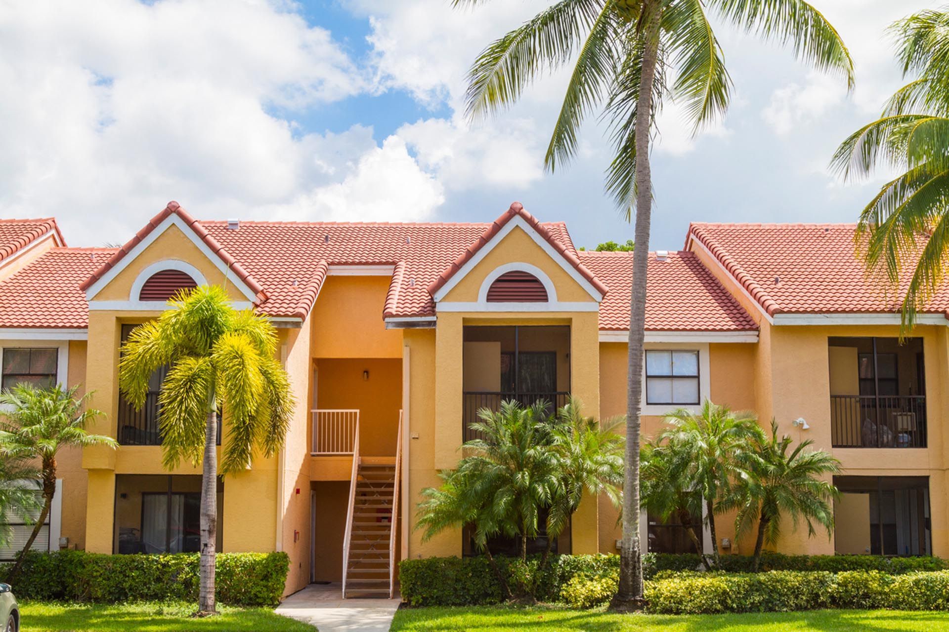 A large apartment building with a palm tree in front of it