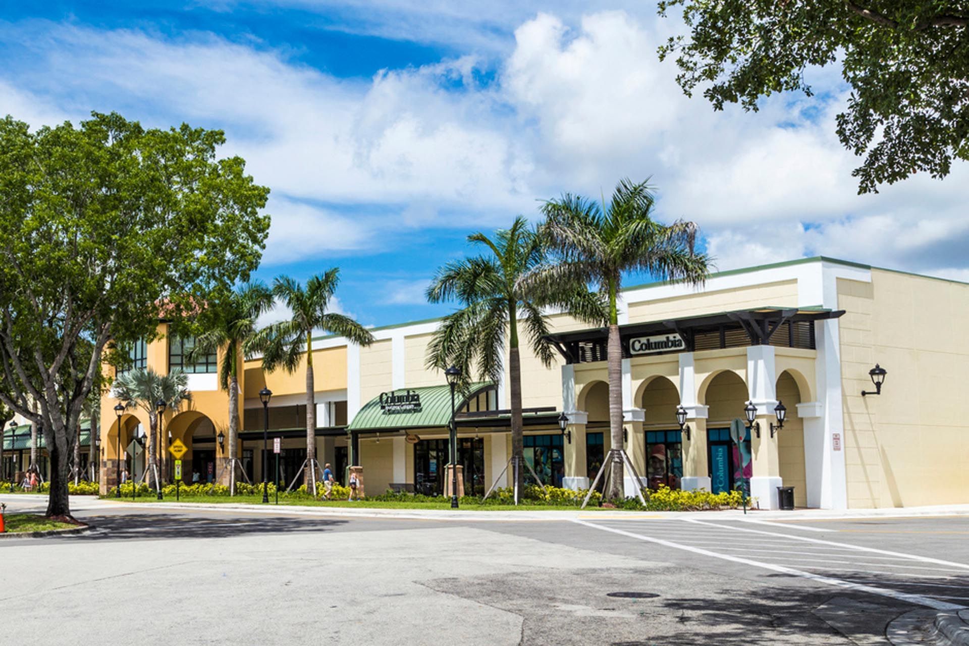 A row of buildings with palm trees in front of them