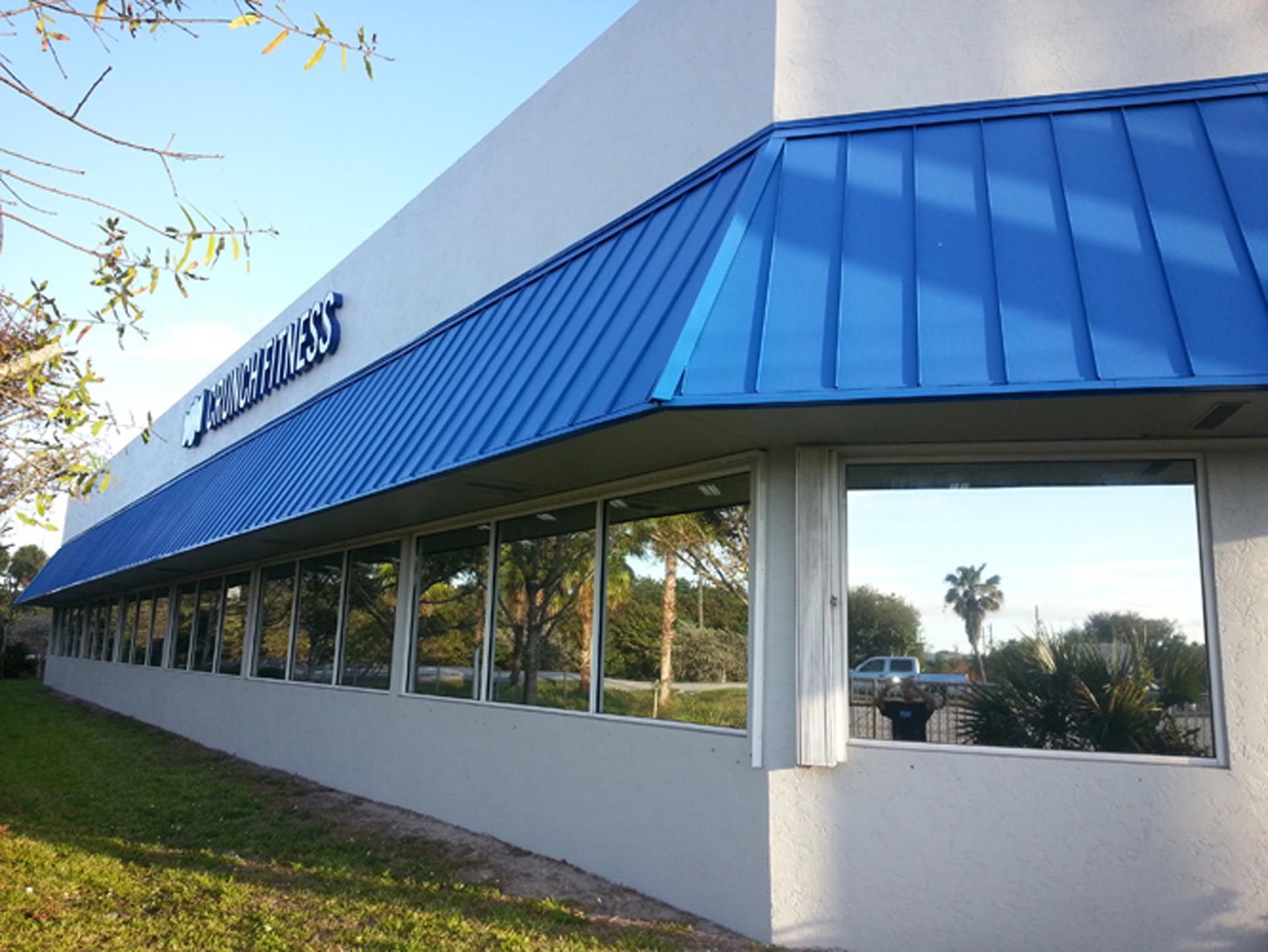 A white building with a blue awning