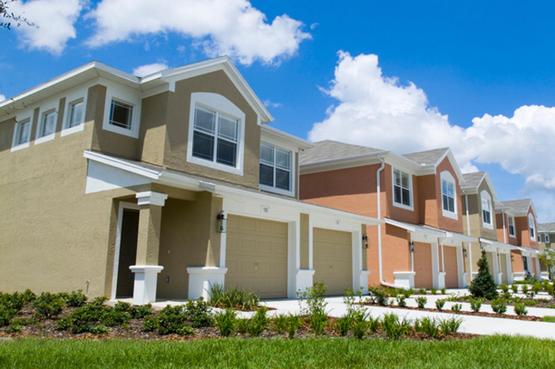 A row of houses with a blue sky in the background