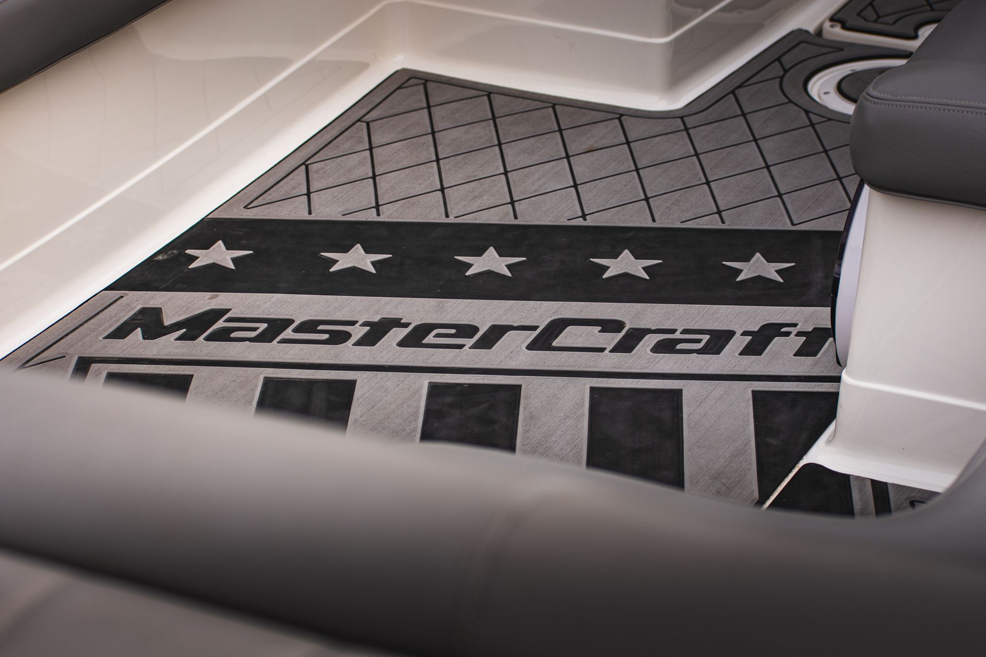 Gray and black MasterCraft boat flooring with stars and stripes design.