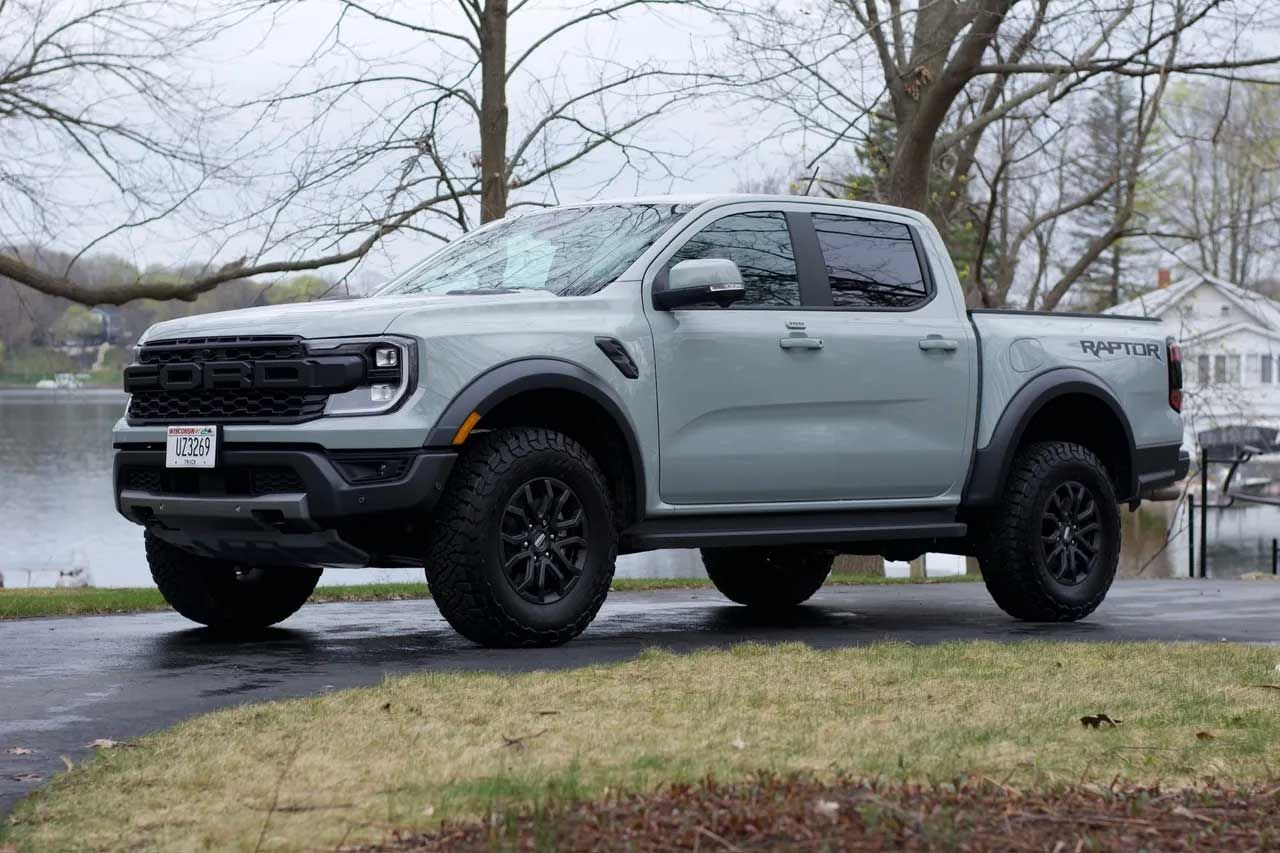 Gray Ford Ranger Raptor parked near water, black wheels, and fender flares.