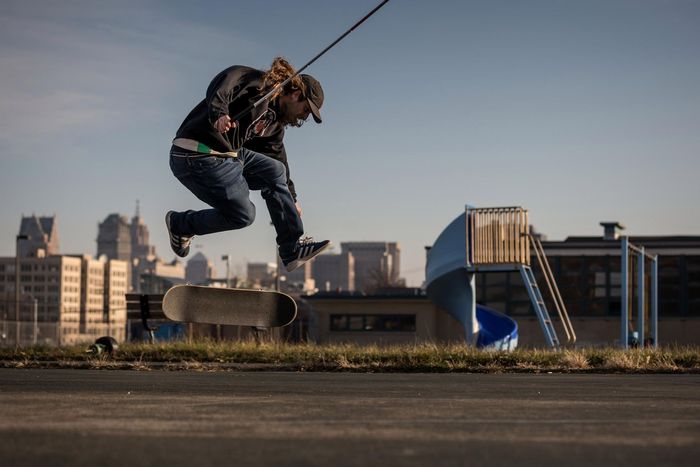 Founder Dan Mancina does a flip trick in front of a city landscape.