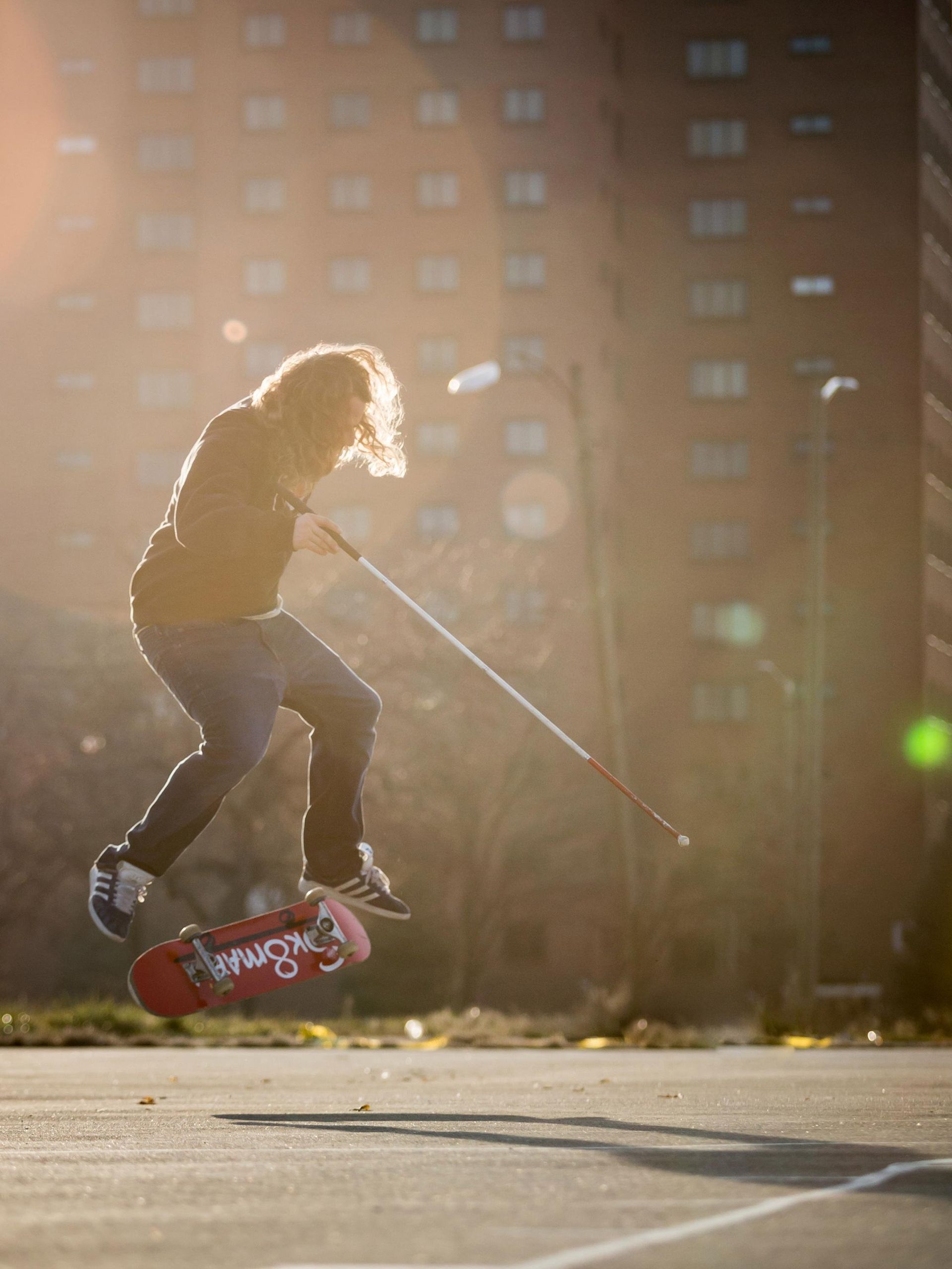 Dan Mancina is mid-air in the middle of a skateboard flip trick.