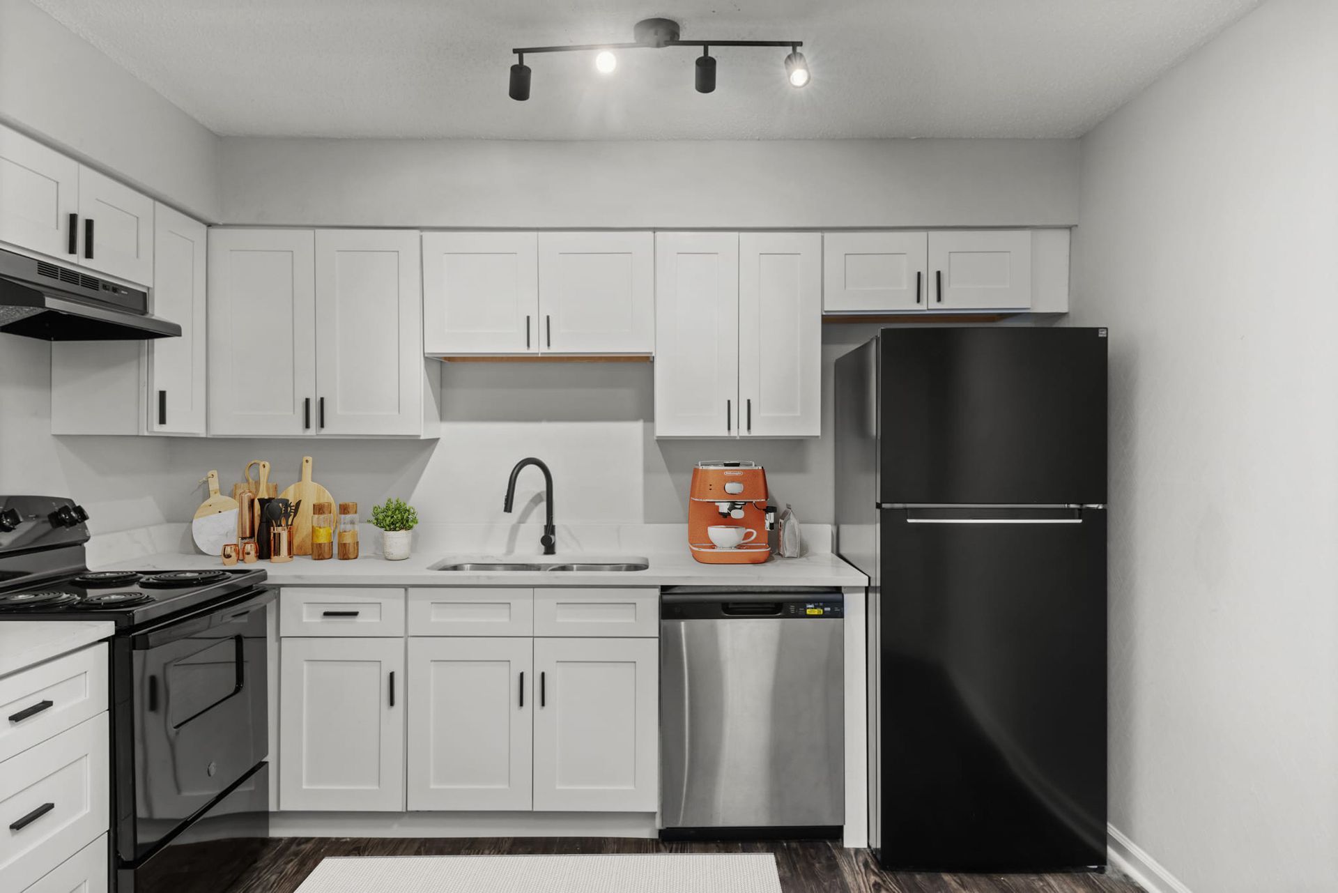 A kitchen with white cabinets , a black refrigerator , a black stove , and a black dishwasher.