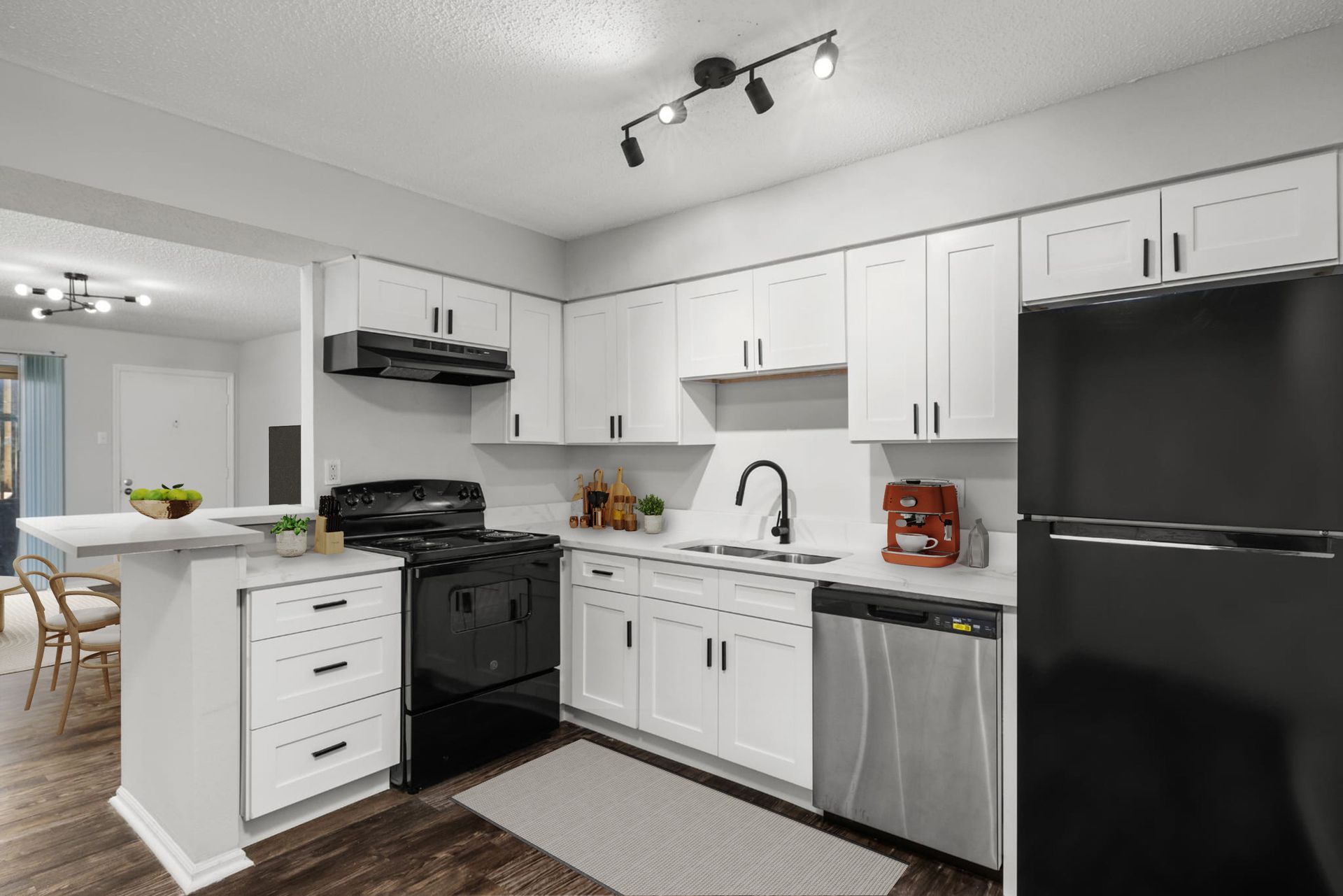 A kitchen with white cabinets , stainless steel appliances , and a black refrigerator.