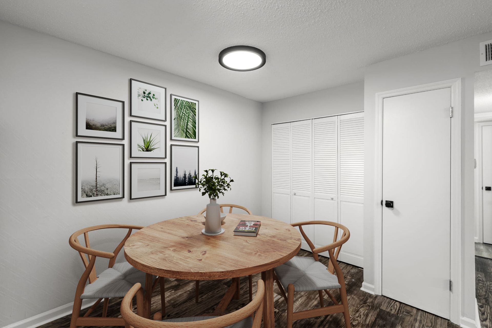 A dining room with a round wooden table and chairs.