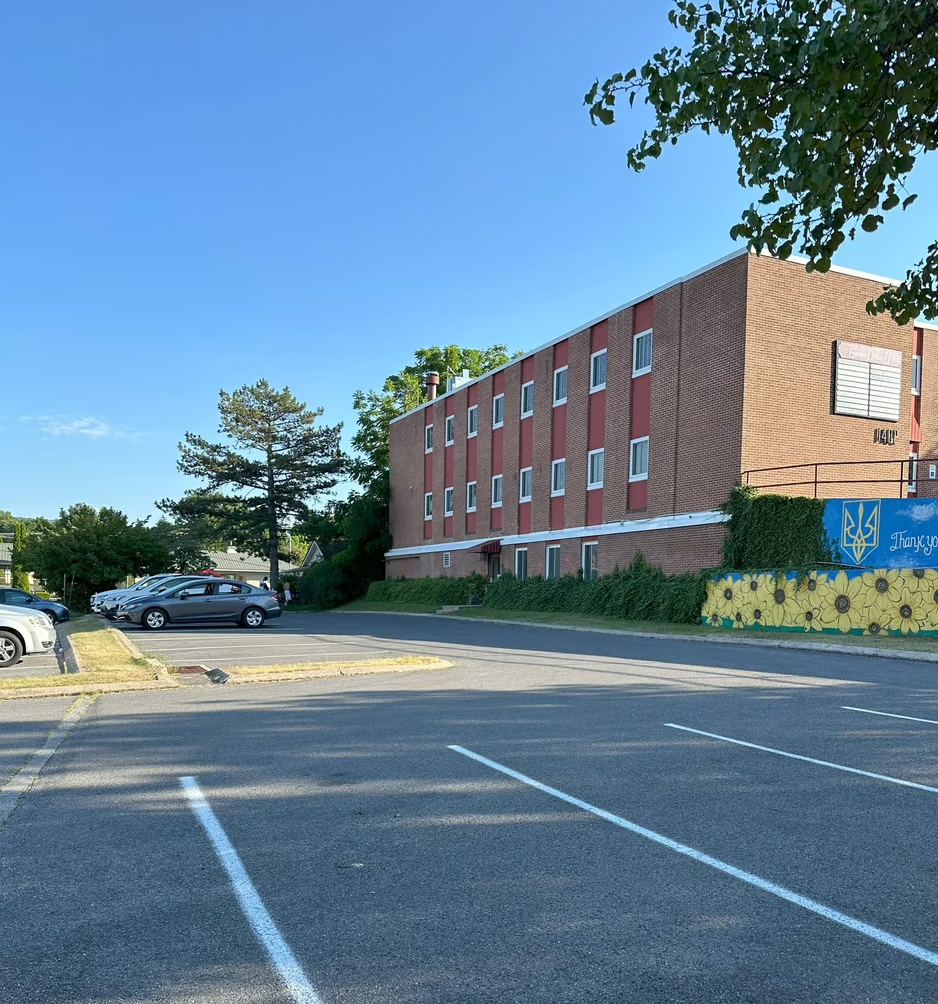 A parking lot with a brick building in the background