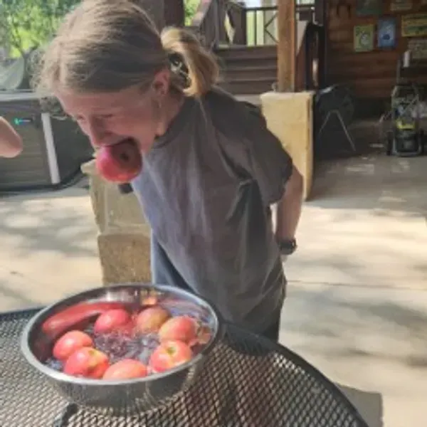 A person is holding a pineapple in a bag in a grocery store.