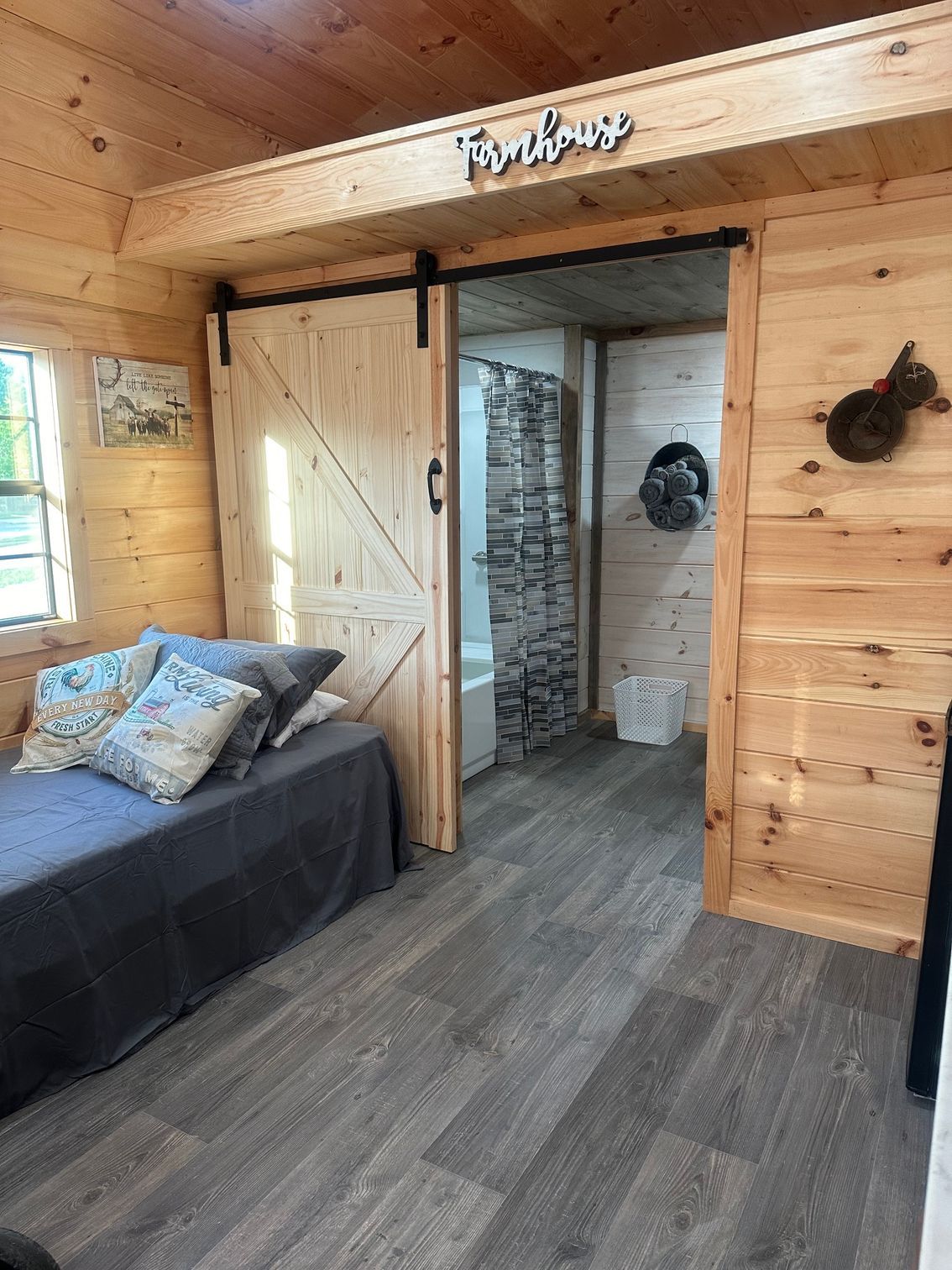 A bedroom in a log cabin with a bed and a sliding barn door.