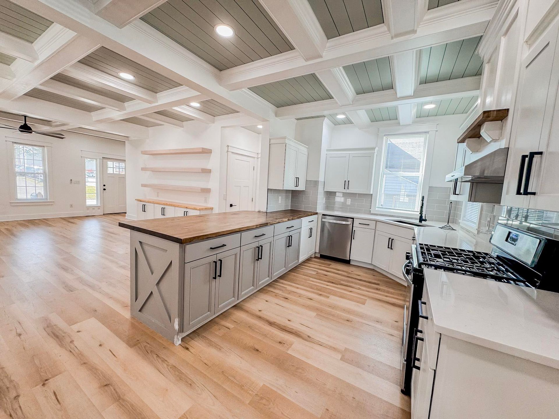 A white house with a large garage and a driveway in front of it.