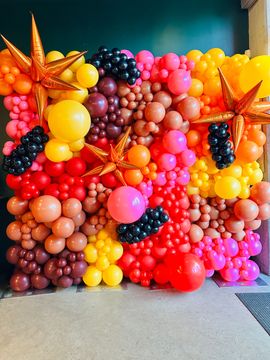 A bunch of balloons are sitting on the floor in a room.