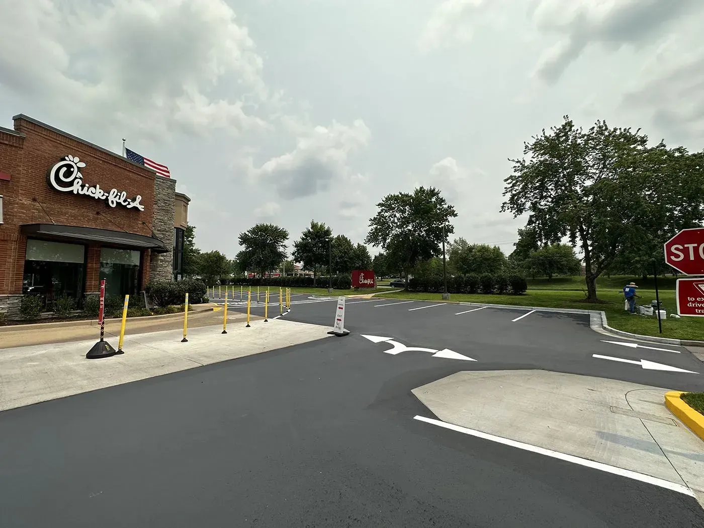 Exterior of a Chick-fil-A restaurant with a freshly paved drive-thru area and directional arrows painted on the asphalt.
