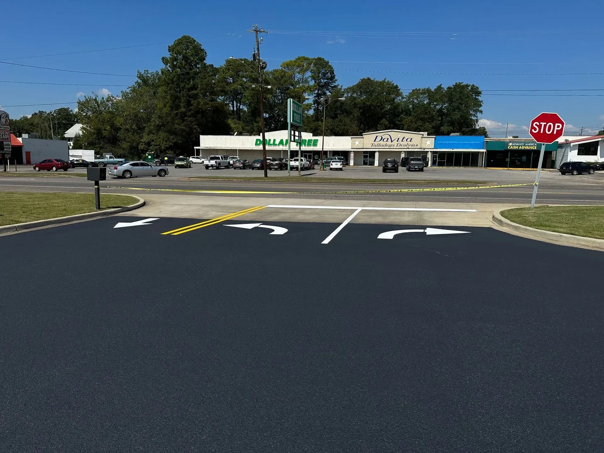 Intersection with stop sign, Dollar General store in background. Arrows indicate turn directions on new asphalt.