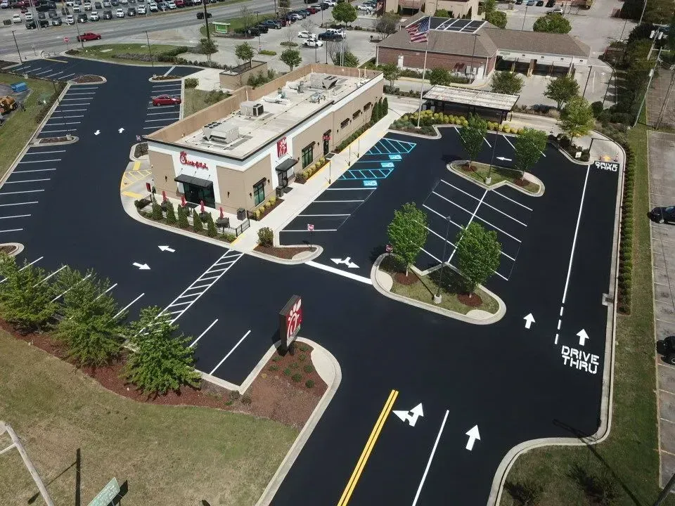Aerial view of a newly paved Chick-fil-A with a freshly painted parking lot and drive-through lanes.