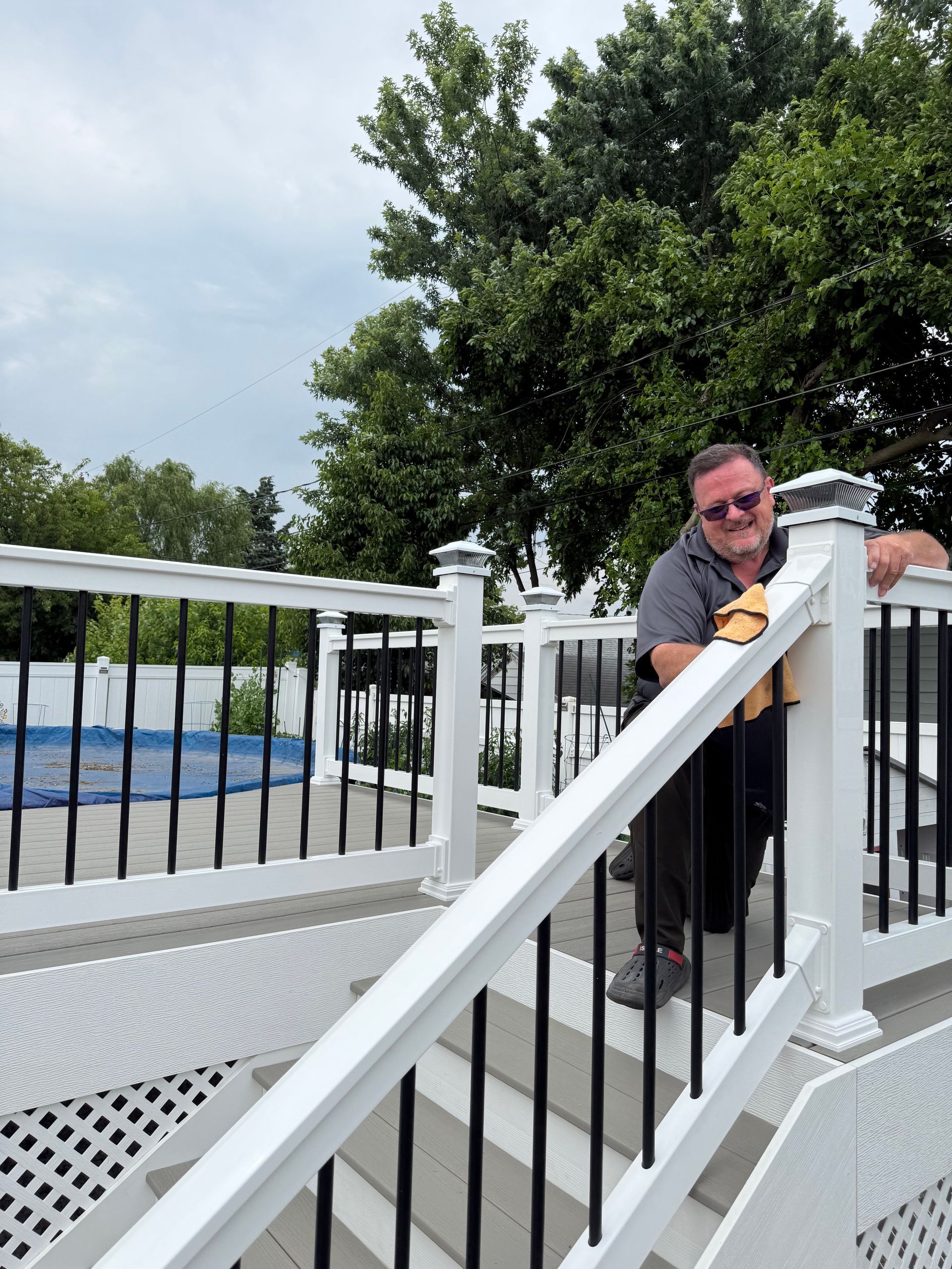 A man leaning on a railing on a deck