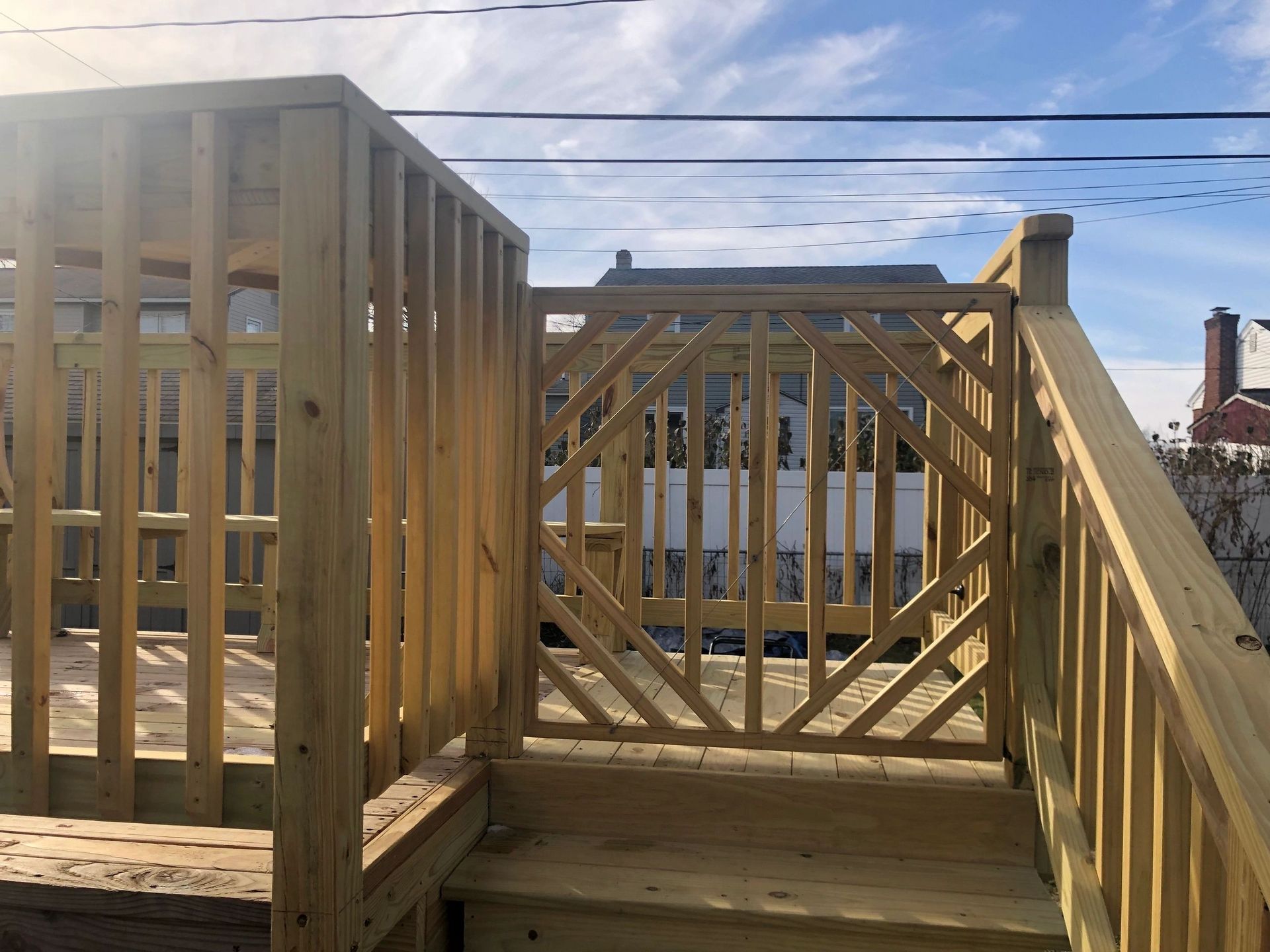 A wooden deck with stairs and a wooden railing