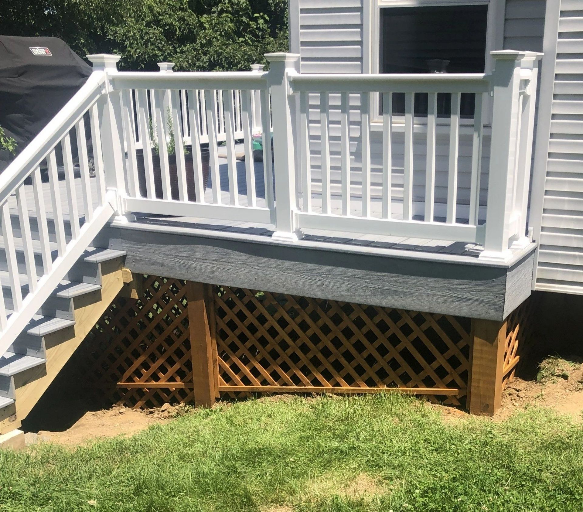 A white deck with stairs leading up to it