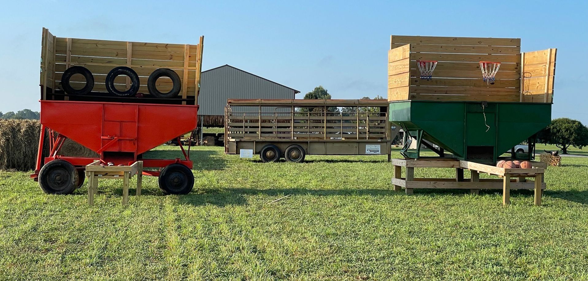 Two tractor trailers are parked in a grassy field.