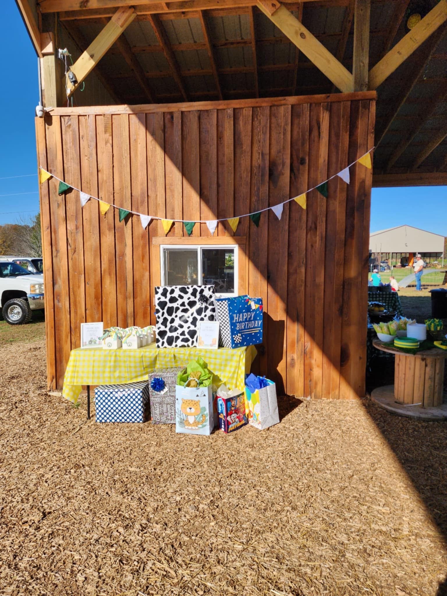 A wooden building with a table and gifts in front of it.