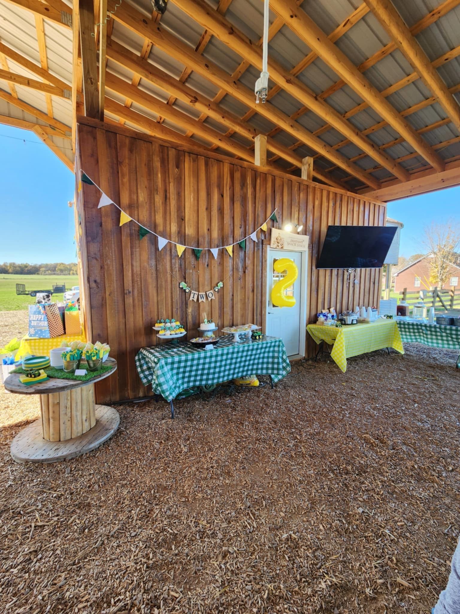 A barn with tables and a television on the wall.